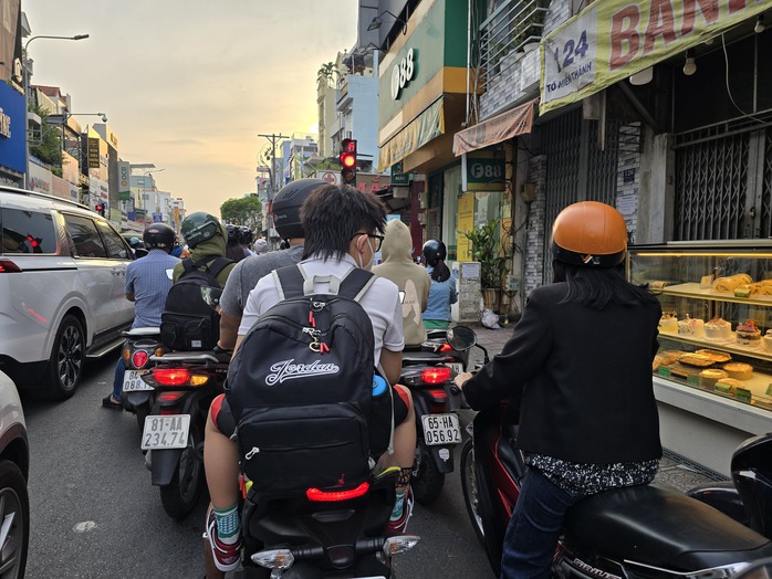 Nhiều người vô tư không đội nón bảo hiểm, chiếm dụng lòng đường ở TP HCM- Ảnh 1. Nhiều người vô tư không đội nón bảo hiểm, chiếm dụng lòng đường ở TP HCM- Ảnh 1.