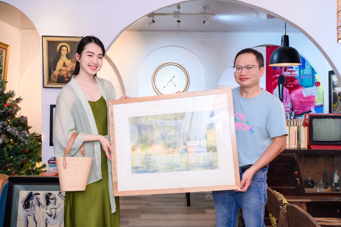 Họa sĩ Phan Anh Thư trao bức tranh “Nhà bên hồ” cho nhà văn Trần Nhã Thụy. Ảnh: B.T.C Họa sĩ Phan Anh Thư trao bức tranh “Nhà bên hồ” cho nhà văn Trần Nhã Thụy. Ảnh: B.T.C