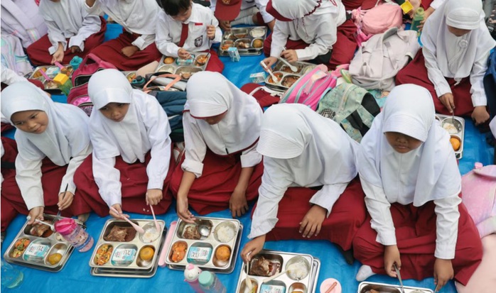 Học sinh tại Trường Tiểu học Lengkong 1 ở Tangerang - Indonesia ăn bữa ăn miễn phí hôm 6-1 Ảnh: EPA-EFE Học sinh tại Trường Tiểu học Lengkong 1 ở Tangerang - Indonesia ăn bữa ăn miễn phí hôm 6-1 Ảnh: EPA-EFE