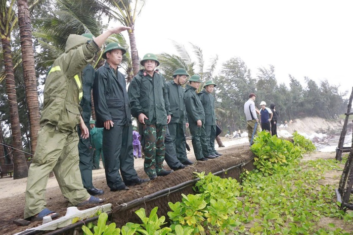 Dân quân Đà Nẵng hỗ trợ người dân vượt đường lầy lội sau bão số 12 - Ảnh 2. Dân quân Đà Nẵng hỗ trợ người dân vượt đường lầy lội sau bão số 12 - Ảnh 2.