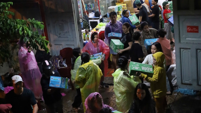 Người dân đội mưa, cùng nhau chuyển hàng cứu trợ kịp chuyến xe từ TP HCM ra miền Trung  - Ảnh 1. Người dân đội mưa, cùng nhau chuyển hàng cứu trợ kịp chuyến xe từ TP HCM ra miền Trung  - Ảnh 1.