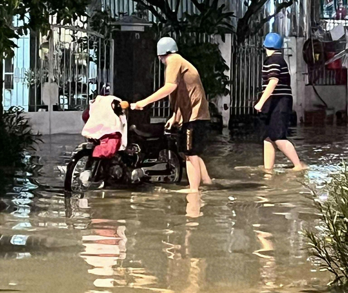 Triều cường dâng cao, người dân TP HCM chèo thuyền trên phố - Ảnh 1.