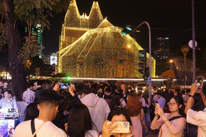 Thợ chụp ảnh dạo hút khách mùa Giáng sinh 2025 tại Nhà thờ Đức Bà - Ảnh 2. Thợ chụp ảnh dạo hút khách mùa Giáng sinh 2025 tại Nhà thờ Đức Bà - Ảnh 2.