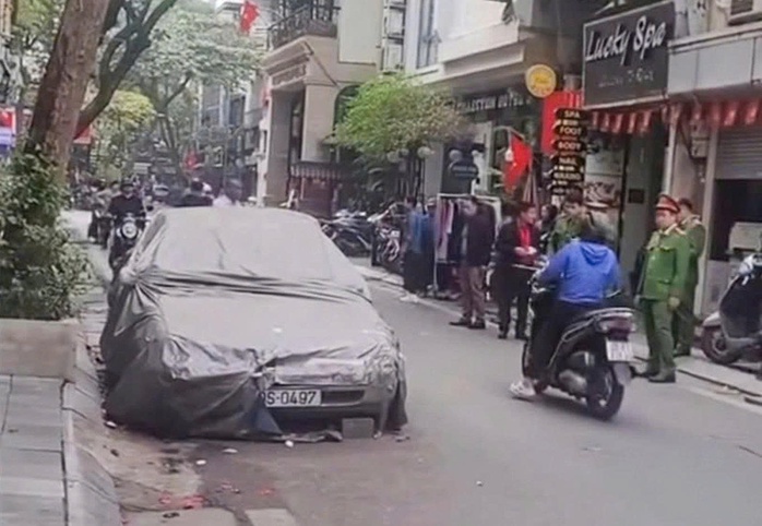 Cẩu ô tô phủ bạt nằm lì 4 năm trên phố Bát Sứ gây ô nhiễm môi trường - Ảnh 1.
