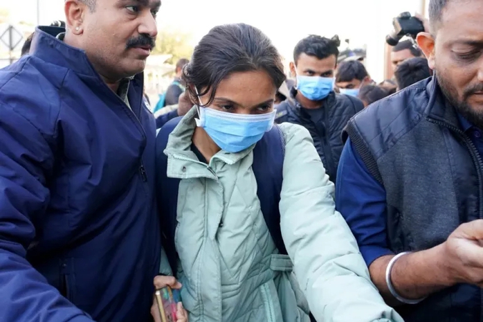 Security personnel escort a group of Gujarati immigrants deported from the United States, after they arrived at Ahmedabad Airport in Ahmedabad, Gujarat, India [Siddharaj Solanki/EPA]
