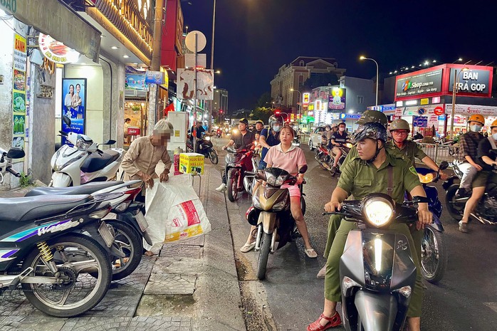 Cảnh trên đường Bạch Đằng, quận Bình Thạnh. Lực lượng chức năng nhắc nhở, yêu cầu cụ bà xin tiền di chuyển đi nơi khác Ảnh: ANH VŨ Cảnh trên đường Bạch Đằng, quận Bình Thạnh. Lực lượng chức năng nhắc nhở, yêu cầu cụ bà xin tiền di chuyển đi nơi khác Ảnh: ANH VŨ