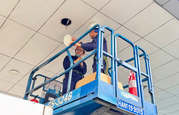 Nhân viên kỹ thuật thay bóng đèn trần nhà ga hành khách Nhân viên kỹ thuật thay bóng đèn trần nhà ga hành khách