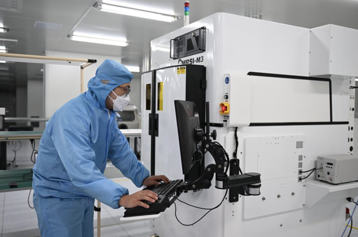 Một nhân viên điều chỉnh thiết bị sản xuất chip tại cơ sở thử nghiệm ở Trung tâm Đổi mới Khoa học và Công nghệ Xiong’an ở tỉnh Hà Bắc - Trung Quốc Ảnh: TÂN HOA XÃ Một nhân viên điều chỉnh thiết bị sản xuất chip tại cơ sở thử nghiệm ở Trung tâm Đổi mới Khoa học và Công nghệ Xiong’an ở tỉnh Hà Bắc - Trung Quốc Ảnh: TÂN HOA XÃ