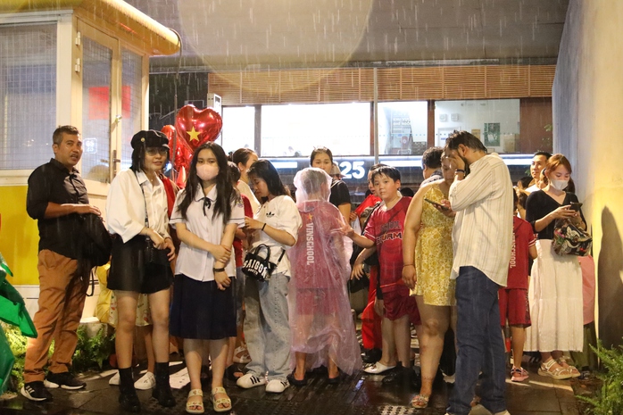 TP HCM bất ngờ mưa lớn, người dân vẫn háo hức chờ sơ duyệt diễu binh, diễu hành - Ảnh 1.