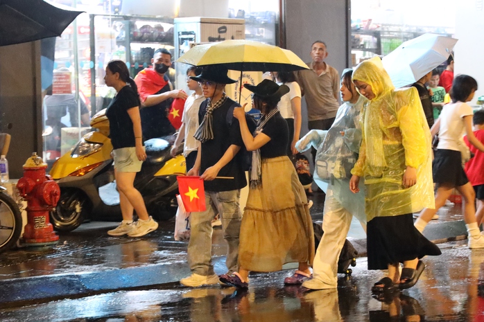 TP HCM bất ngờ mưa lớn, người dân vẫn háo hức chờ sơ duyệt diễu binh, diễu hành - Ảnh 3.
