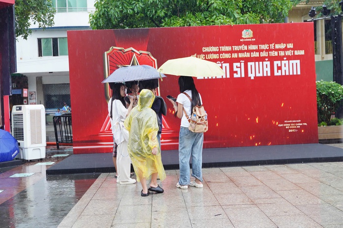 Người dân TP HCM đội mưa "check-in" sự kiện "Vinh quang Công an nhân dân Việt Nam" - Ảnh 4.