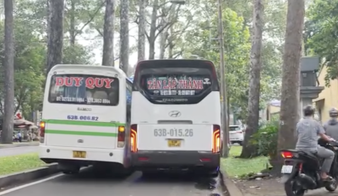 Hai xe khách TP HCM dàn hàng ngang , xe máy buộc phải leo vỉa hè - Ảnh 1.