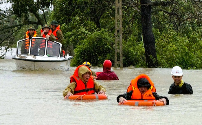 Cảnh sát căng dây, ngâm mình trong nước lũ giải cứu 22 người mắc kẹt trong bão số 10- Ảnh 1.