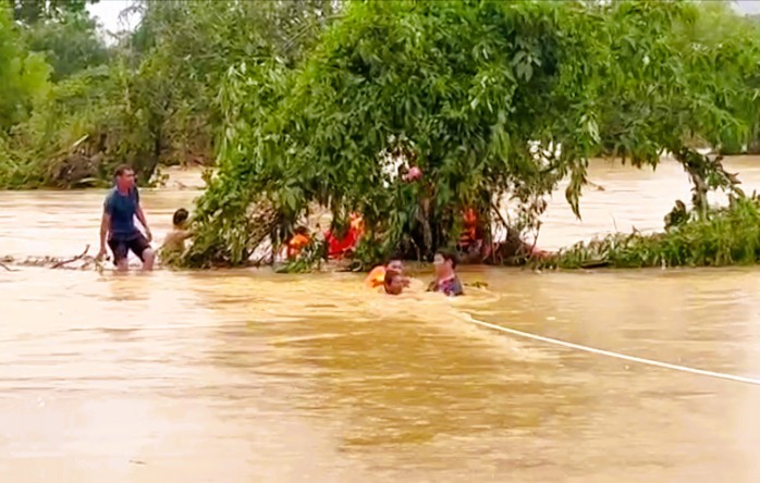 Cảnh sát căng dây, ngâm mình trong nước lũ giải cứu 22 người mắc kẹt trong bão số 10- Ảnh 2.