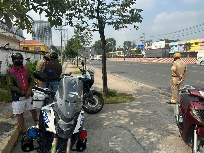 CSGT nhắc nhở người dân không chạy xe máy lên cầu vượt ngã tư 550 tại TP HCM - Ảnh 1. CSGT nhắc nhở người dân không chạy xe máy lên cầu vượt ngã tư 550 tại TP HCM - Ảnh 1.