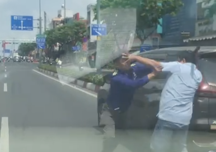 Hai người đ&agrave;n &ocirc;ng đ&aacute;nh nhau tr&ecirc;n đường Phạm Văn Đồng , TPHCM g&acirc;y ch&uacute; &yacute; - Ảnh 1.