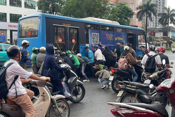 Gần 20 người n&acirc;ng xe bu&yacute;t cứu người phụ nữ mắc kẹt dưới gầm - Ảnh 1.