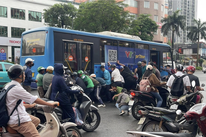 H&agrave;ng chục người n&acirc;ng xe bu&yacute;t cứu phụ nữ gặp nạn tại H&agrave; Nội - Ảnh 1.
