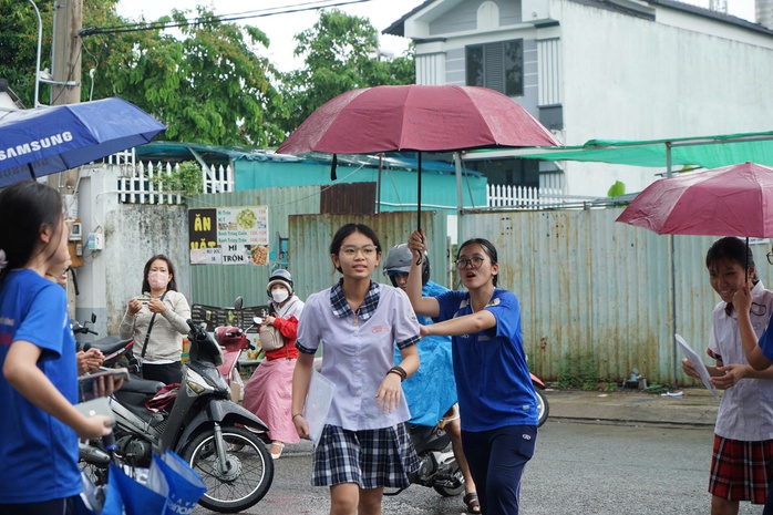 Mưa bất chợt, học sinh vẫn đội mưa tiếp sức th&iacute; sinh - Ảnh 4.