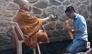 Người mặc đồ nhà sư đọc thần chú, vẩy nước thánh tại chùa Hương Tích