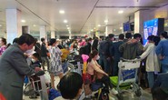 Hành khách vạ vật ở sân bay Tân Sơn Nhất rạng sáng 7-2 chờ lấy hành lý, gọi xe