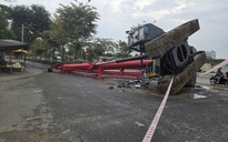 Dây xích bị đứt, xe cần cẩu đổ xuống đường ở TP HCM