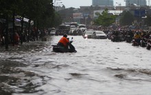 CLIP: Nước cuồn cuộn cuốn ngã xe máy trong cơn mưa xối xả ở TP HCM