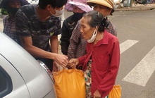 Hai người đàn ôngchạy vòng vòng phát gạo cho người bán vé số