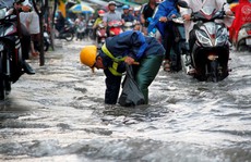 Người dân TP HCM 'bì bõm' sau cơn mưa lớn