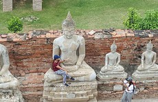 Nữ du khách bị “ném đá” vì ngồi vào lòng tượng Phật
