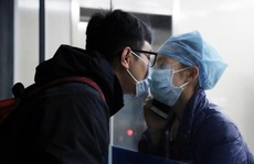 Giữa đại dịch virus corona, nữ y tá hôn bạn trai qua tấm kính cách ly
