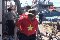 Ngư dân La Gi thoăn thoắt lên nóc tàu thay mới cờ Tổ quốc