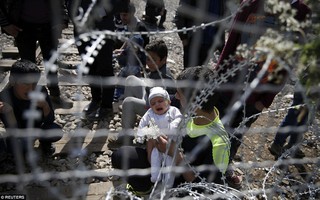 Người tị nạn dọa ném trẻ em qua hàng rào thép gai