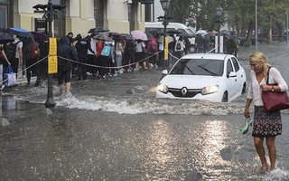 Mưa lớn, xe cộ bị nhấn chìm, người bơi trên phố