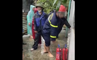 Cảnh sát cùng người dân múc nước lụt để chữa cháy nhà