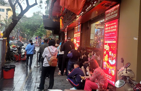 Người dân đội mưa xếp hàng chờ mua vàng trước ngày vía Thần Tài