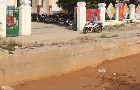 Quốc lộ 14B đào xới dang dở, dân vượt “hào sâu” mới vào được cổng ủy ban